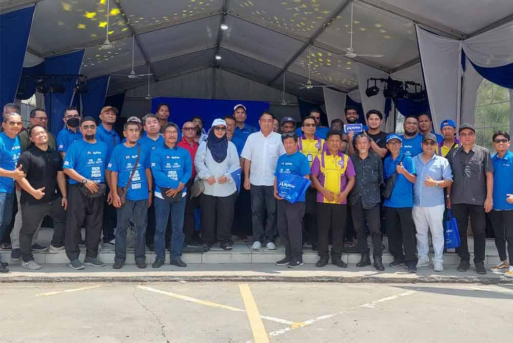 Azleen bergambar bersama pemandu MyRide berdaftar pada majlis pelancaran aplikasi e-hailing itu peringkat nasional pada Rabu.