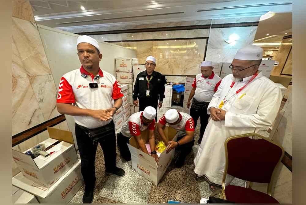 Zahari (dua dari kiri) melihat sendiri proses penghantaran barang jemaah haji oleh Pos Malaysia Berhad di Hotel Abraj Al-Janadriyah, semalam.