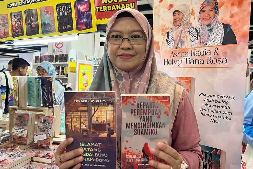 Shahida menunjukkan novel &#039;Selamat Datang ke Kedai Buku Hyunam-Dong&#039; dan &#039;Kepada Perempuan Yang Menginginkan Suamiku&#039; yang dijual di reruai Karangkraf sempena PBAKL 2024 di WTCKL.