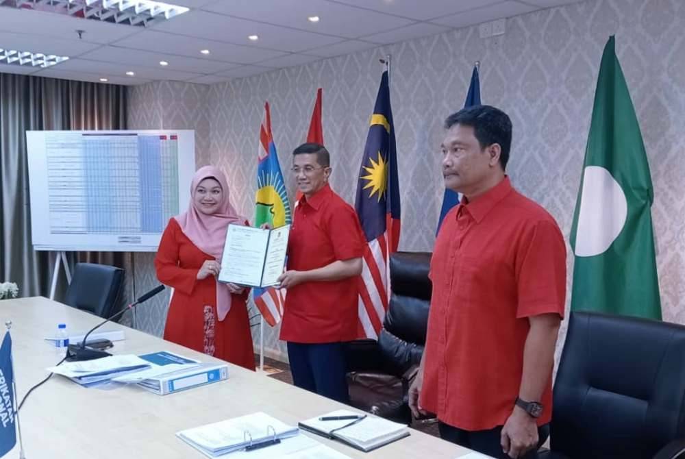 Nurul Syazwani (kiri) menerima watikah pelantikan daripada Mohamed Azmin (tengah) di Ibu Pejabat PN di Kuala Lumpur pada 20 Mei lalu.