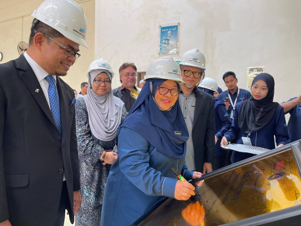 Mashitah menandatangani plak perasmian ZABSI Training Academy Sdn Bhd sambil disaksikan Ir Ts Mohd Zainudin (kiri) di Kolej Universiti TATI (UC TATI) di Kemaman, Terengganu pada Khamis, 30 Mei 2024.