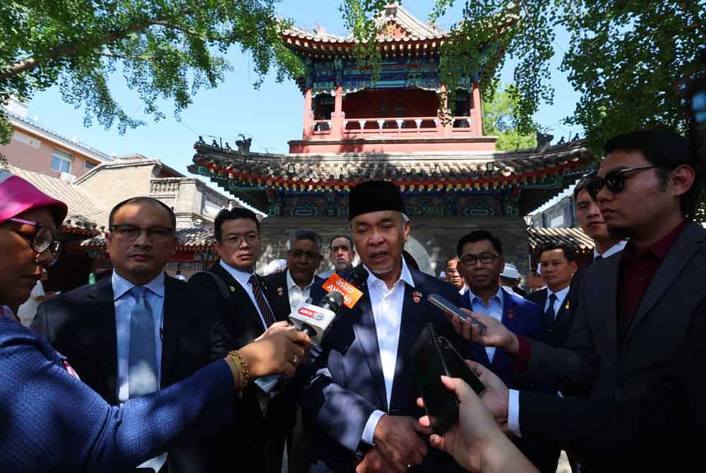 Ahmad Zahid (tengah) ketika ditemui media Malaysia selepas menunaikan solat Jumaat di Masjid Dongsi hari ini. Foto Bernama