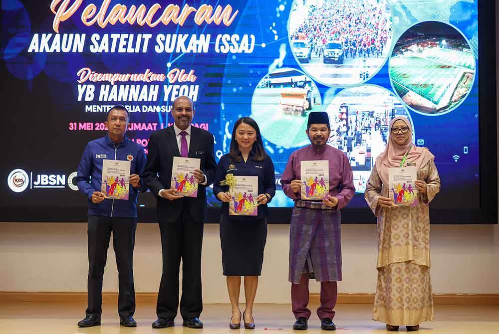 Hannah (tengah) dan Mohd Uzir (dua, kanan) menunjukkan buku laporan awalan Akaun Satelit Sukan 2022 pada Pelancaran Akaun Satelit Sukan di Menara KBS pada Jumaat.