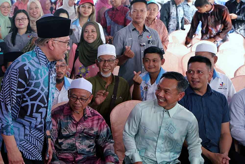 Anwar (kiri) beramah mesra dengan orang ramai ketika menghadiri sesi santai komuniti di Jeti Terminal RORO Feri Kenderaan Labuan hari ini. Foto Bernama