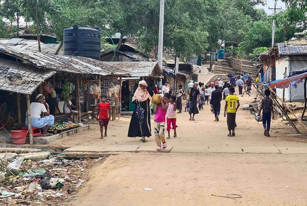 Foto pada 24 Mei lalu menunjukkan pelarian Rohingya berjalan menyusuri laluan di kem mereka di Ukhia di daerah Cox&#039;s Bazar, tenggara Bangladesh. - AFP