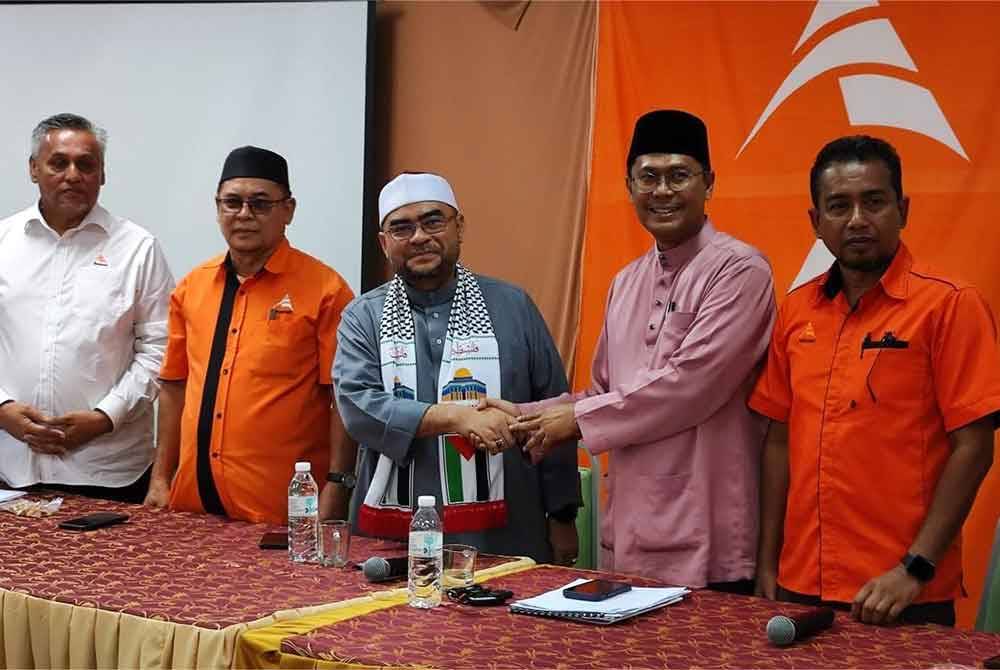 Mujahid (tiga dari kiri) bersalaman dengan Mohd Asmirul (dua dari kanan) ketika hadir sesi libat urus bersama jawatankuasa pimpinan, sayap dan kawasan Amanah Kedah, di Wisma Amanah.