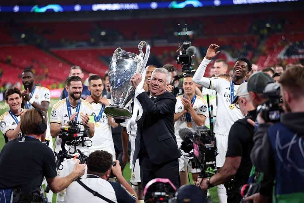 Ancelotti menjulang trofi yang dimenangi Real Madrid selepas menewaskan Borussia Dortmund dalam perlawanan UCL di Stadium Wembley, London, Britain, 1 Jun 2024. - Foto: EPA