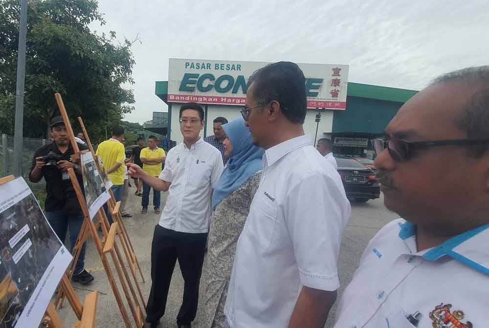 Zairil (kiri) memberi penerangan kepada Mohamad mengenai projek mitigasi banjir DUN Sungai Bakap yang akan dijalankan pada penghujung Jun ini.