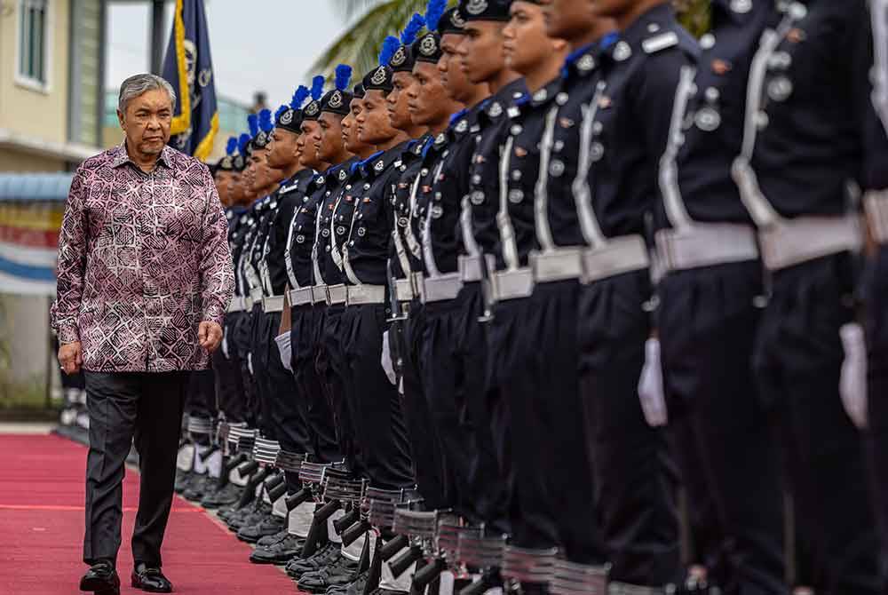 Ahmad Zahid memeriksa barisan kawalan kehormat ketika hadir melancarkan pengoperasian IPD Bagan Datuk di Hutan Melintang hari ini. - Foto: Bernama