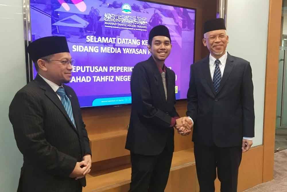 Mahmud (kanan) mengucapkan tahniah kepada Akif yang turut hadir pada sesi sidang akhbar di Yayasan Pahang pada Selasa.