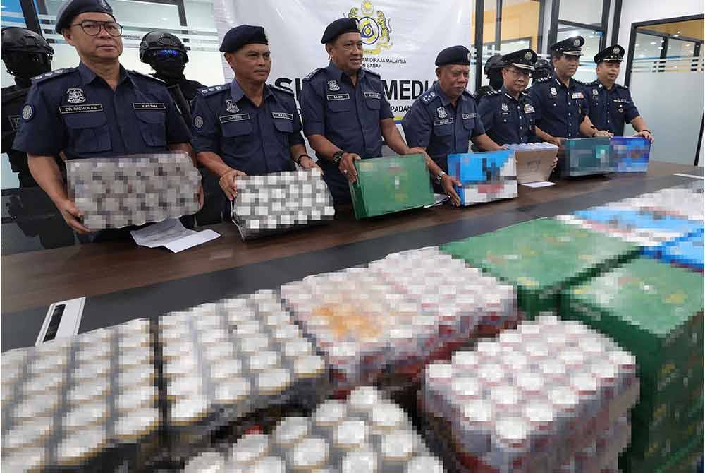 Penolong Ketua Pengarah Kastam Zon Sabah, Datuk Mohd Nasir Deraman (empat dari kiri) bersama pegawai Kastam menunjukkan rampasan minuman keras susulan penahanan tiga kontena di Pelabuhan Sepanggar pada Selasa. Foto Bernama