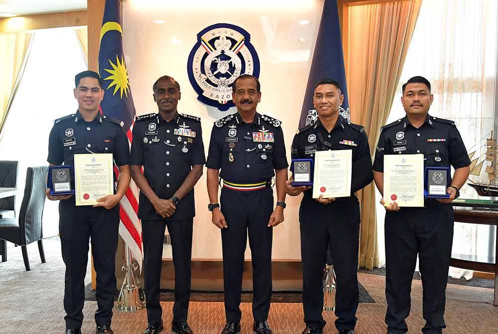 Razarudin (tengah) dan M Kumar bergambar bersama tiga anggota Balai Polis Ulu Tiram di Bukit Aman, pada Selasa. Foto PDRM