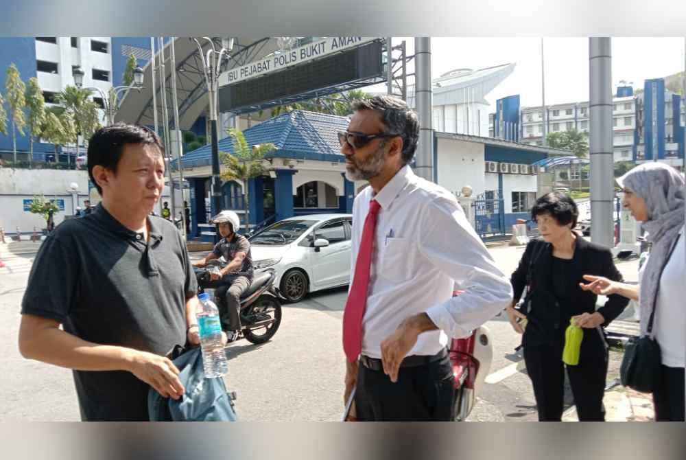 Pemandu e-hailing berkenaan (kiri) bersama N. Surendran dan Latheefa Koya di pekarangan pintu hadapan Ibu Pejabat Polis Bukit Aman pada Rabu.