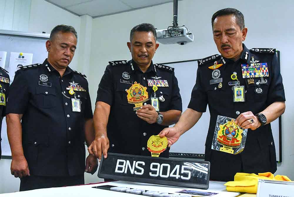 Muhamad Zaki (kanan) bersama pegawai menunjukkan logo kerabat diraja palsu yang dirampas ketika ditemui pemberita sempena Program Townhall Ketua Polis Kelantan 2024 di Politeknik Jeli hari ini. - Foto: Bernama