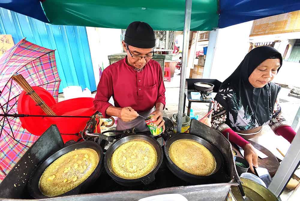 Almidar (kiri) dan Irnawati mula berniaga apam balik sejak tahun 1984.