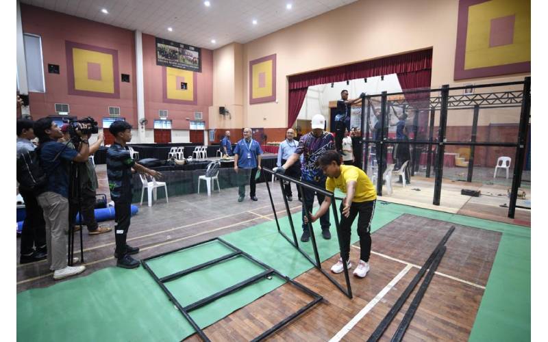 Pekerja sedang giat menyiapkan ruang aktiviti permainan robotik sempena sambutan HTN 2024 di ILP Kuala Langat, Banting.