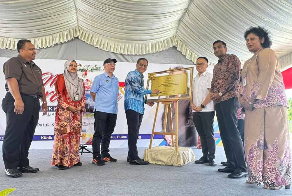 Dzulkefly (empat dari kiri) menandatangani plak ketika merasmikan Klinik Kesihatan Air Putih, Balik Pulau pada Jumaat.