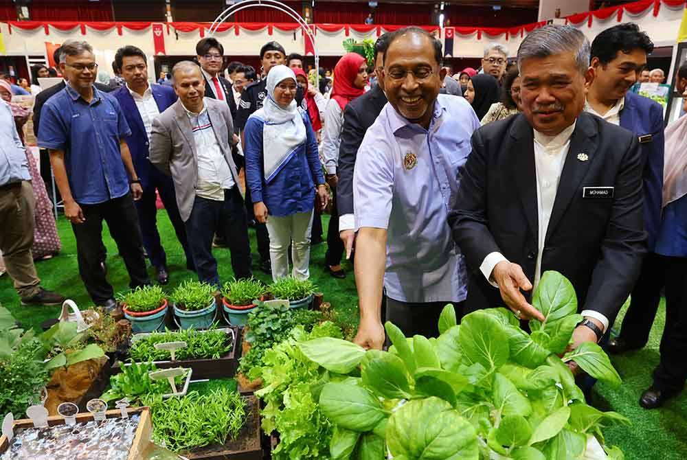 Mohamad (kanan) bersama Zambry (dua darikanan) melawat ruang pameran dan jualan pada Majlis Pelancaran Blueprint Keterjaminan Makanan UPM di UPM pada Jumaat. Foto Bernama