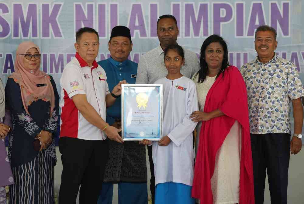 Divyana menerima sijil MBR ‘Most International Flags Identified by a Child in a Minute’ dari wakil MBOR, Edwin Yeoh Tiong Chin selepas berjaya memecah rekod tersebut pada Jumaat. Foto Bernama