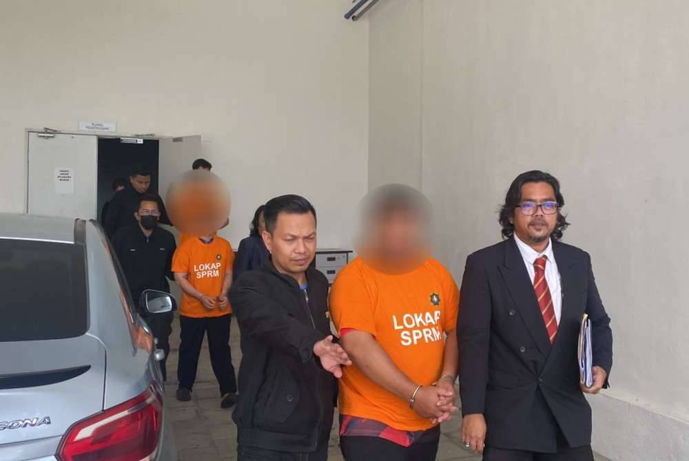 Tiga suspek diiringi anggota SPRM di Mahkamah Kangar pada Ahad.