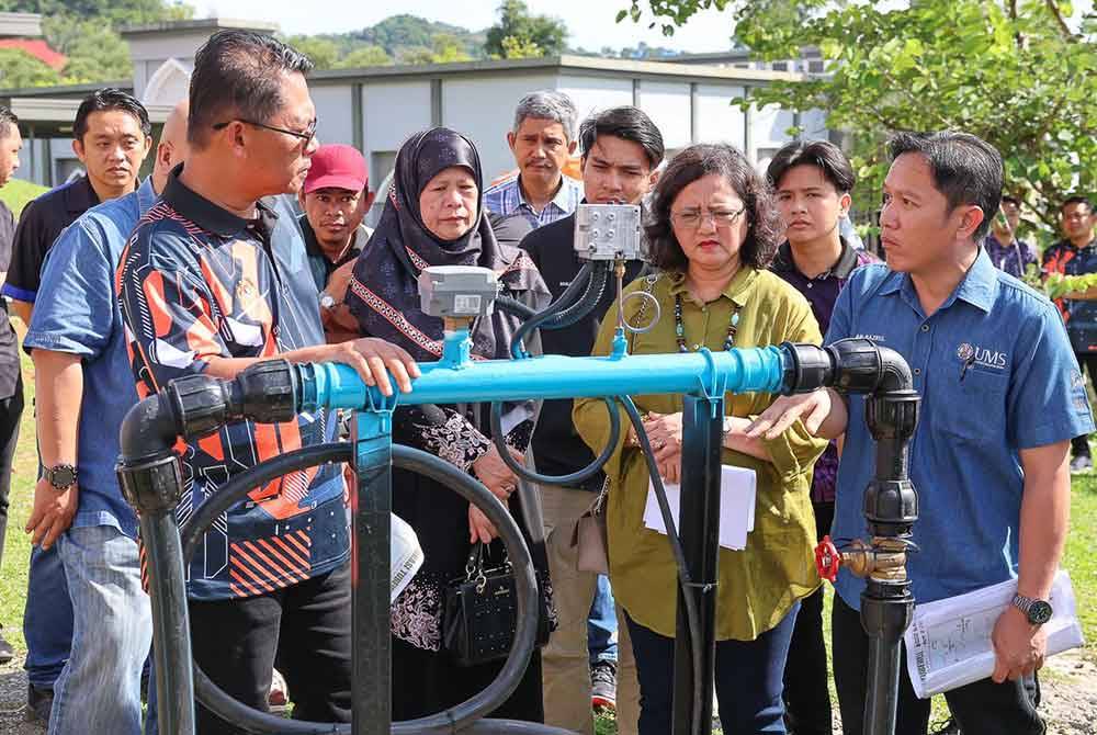 Mustapha (depan, kiri) melawat tapak projek telaga tiub yang dibina di kawasan Masjid UMS.