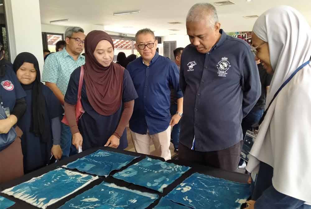 Khairudin (dua dari kanan) melihat hasil kerja peserta ketika hadir merasmikan penutupan Program Kem Belia Kreatif 2024 di Bazar Ipoh, Silveritage di sini pada Ahad.