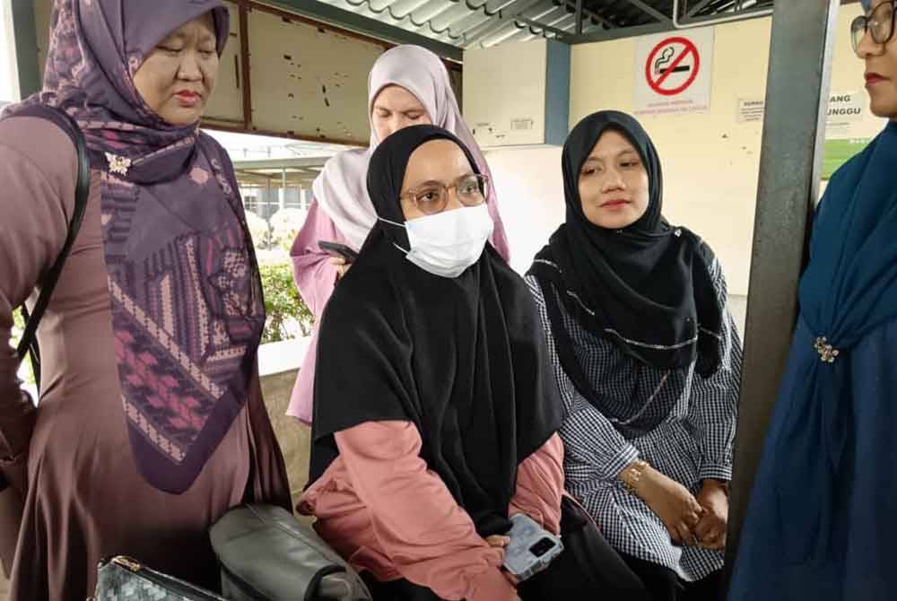 Siti Zulaikha (berpelitup muka) ketika ditemui pemberita di Unit Forensik HTAA di sini pada Ahad.