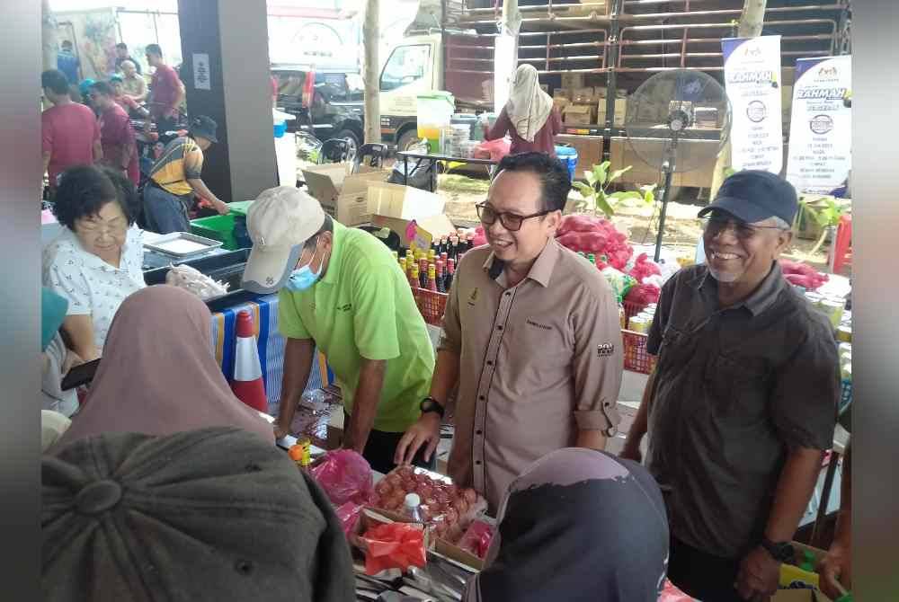 Kamalludin (dua dari kanan) bertemu pengunjung Jualan Rahmah sempena Majlis Pembentangan Laporan Kemajuan Tahun Kedua Perak Sejahtera 2030 di Dewan Merdeka, Seri Manjung di sini pada Isnin.