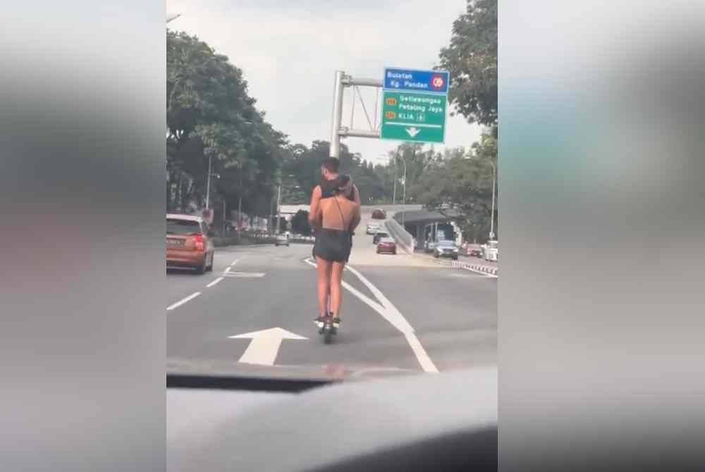 Tangkap layar rakaman video memaparkan pasangan yang menaiki skuter elektrik di Jalan Bukit Bintang, Kuala Lumpur.