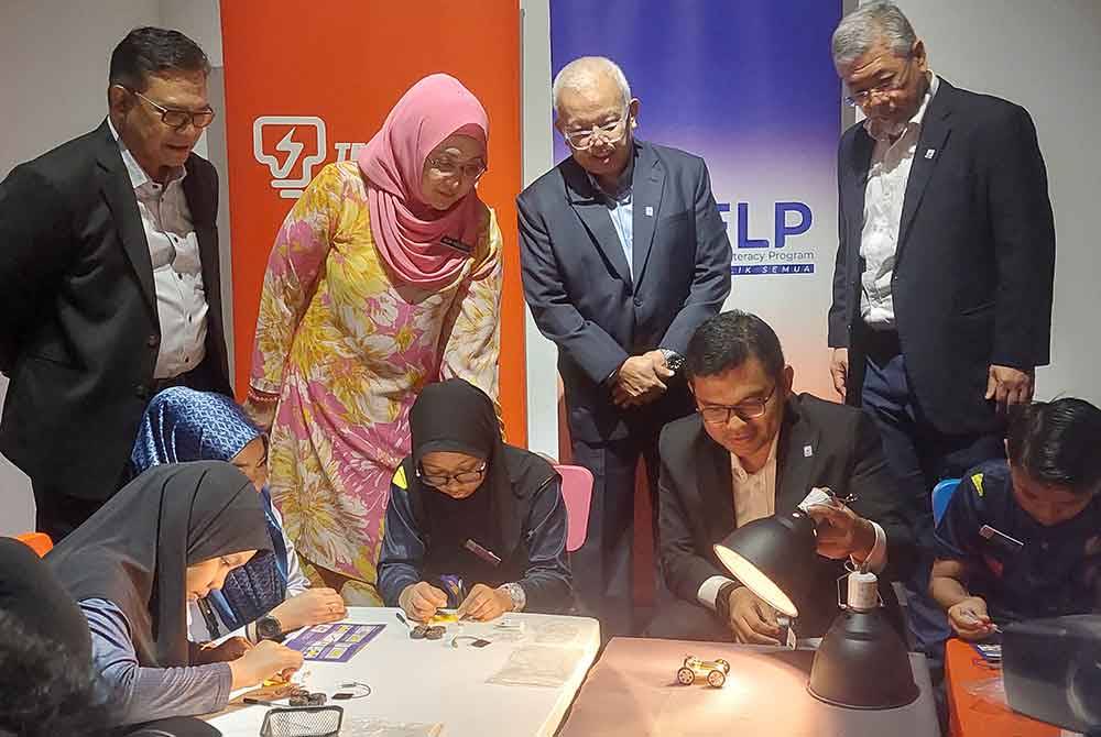 Akmal Nasrullah (duduk, depan kanan) melayani murid yang mencuba aktiviti interaktif di Green Guardian Centre, Pusat Sains Negara, Kuala Lumpur pada Selasa.