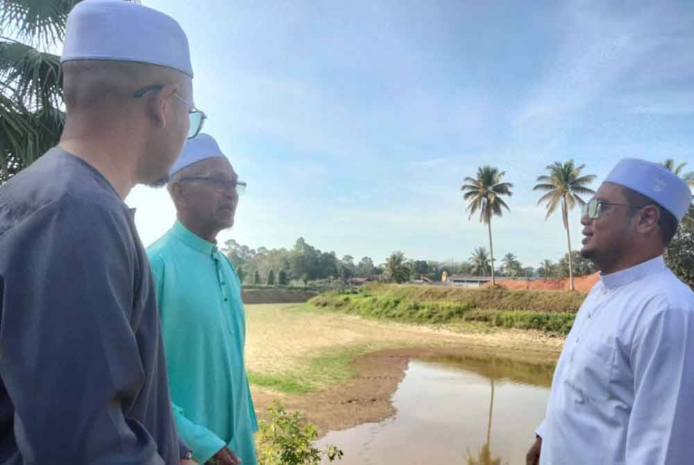 Muhammad (tengah) ketika melakukan lawatan di Stesen Pam Kemubu April lalu untuk meninjau kesan kemarau.