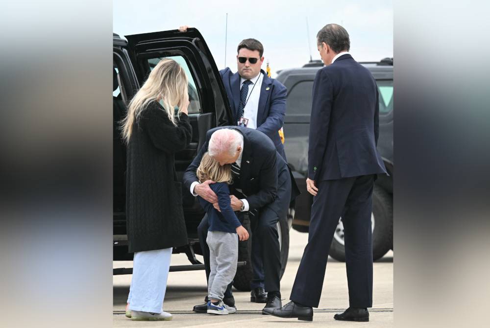 Biden memeluk cucunya, Beau yang juga anak kepada Hunter (kanan) bersama pasangannya, Melissa sejurus beliau tiba di Pangkalan Udara Pengawal Negara Delaware di New Castle pada Selasa. Foto AFP