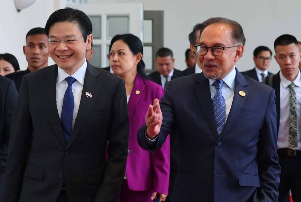 Anwar (kanan) bersama Lawrence selepas mengadakan pertemuan empat mata sempena lawatan kerja perdana menteri Singapura itu ke Malaysia di Kompleks Seri Perdana pada Rabu.