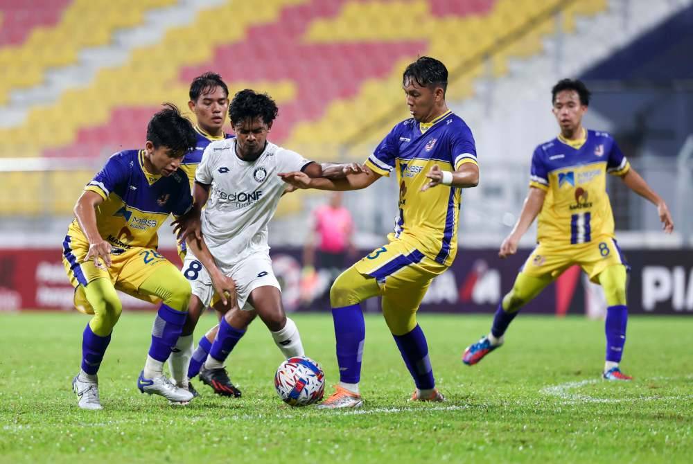 Pemain PDRM FC, Muhammad Zuhair Aizat diasak oleh empat pemain Malaysian Universiti pada perlawanan Piala FA di Stadium Majlis Perbandaran Selayang, pada Rabu. Foto Bernama