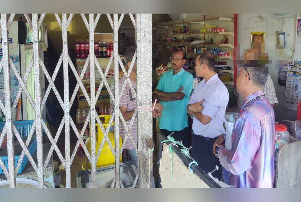 Mohd Faiz (dua dari kanan) semasa operasi dilakukan di sebuah kedai runcit di Bandar Malawati di sini pada Khamis.