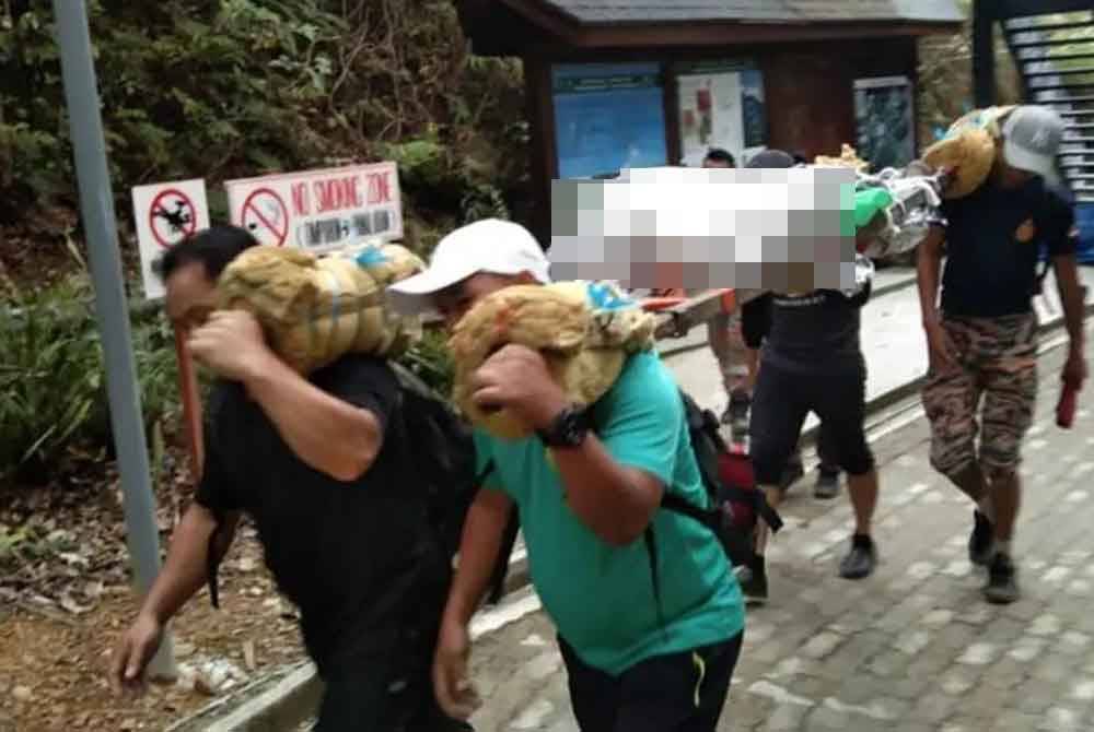 Pasukan Mosar mengusung mayat mangsa untuk dihantar ke Hospital Ranau. Foto ihsan PDRM