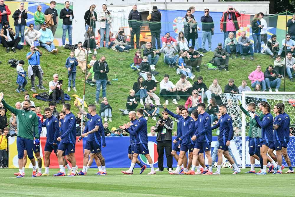 Pemain Itali menyantuni peminat yang hadir semasa sesi latihan terbuka di Iserlohn, Jerman. Foto AFP