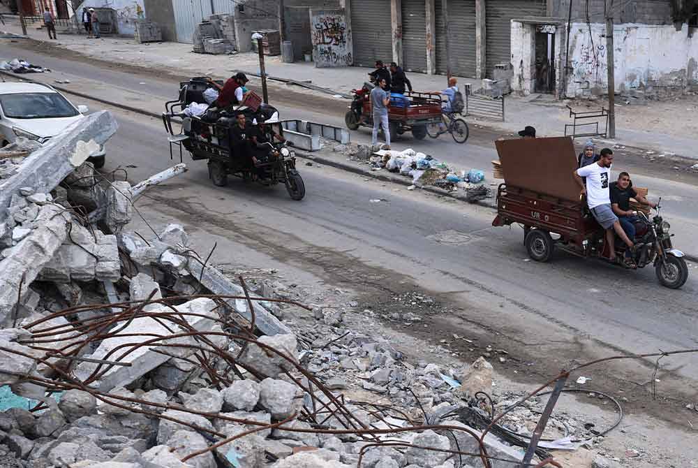 Penduduk Palestin berpindah dari Rafah dengan menaiki motosikal sambil membawa barangan peribadi masing-masing. (Gambar fail) Foto AFP