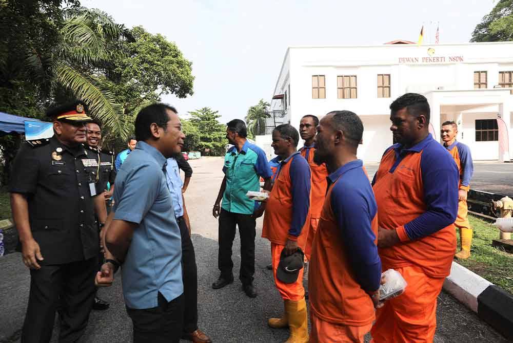 Ahmad Husaini (dua dari kiri) bermesra bersama pekerja pembersihan.