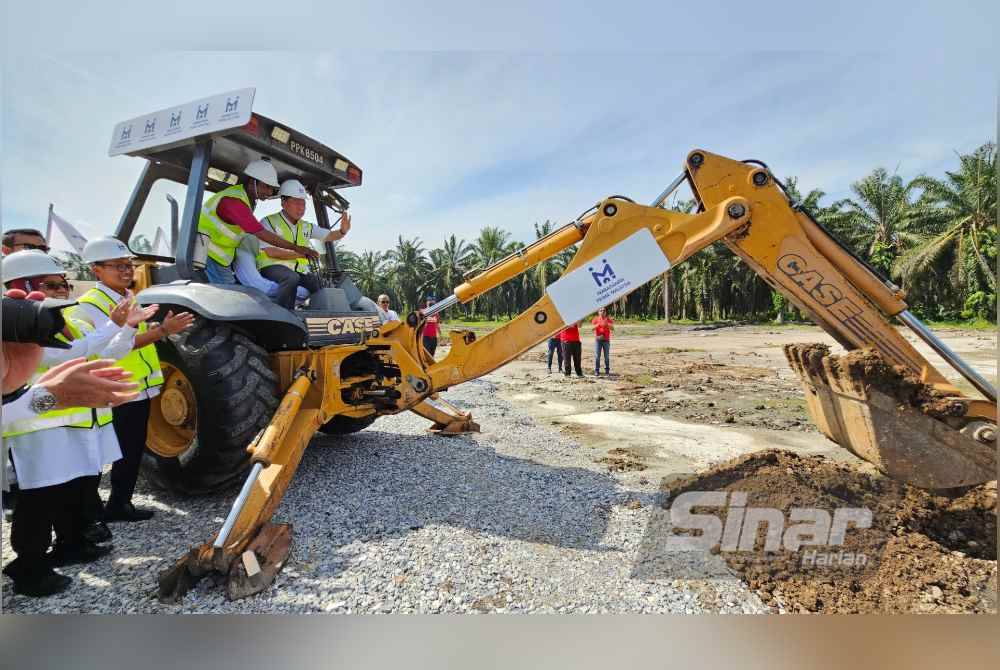 Kor Ming mengendalikan jengkaut simbolik merasmikan pembangunan Bandar PR1MA pertama negara di Teluk Intan.