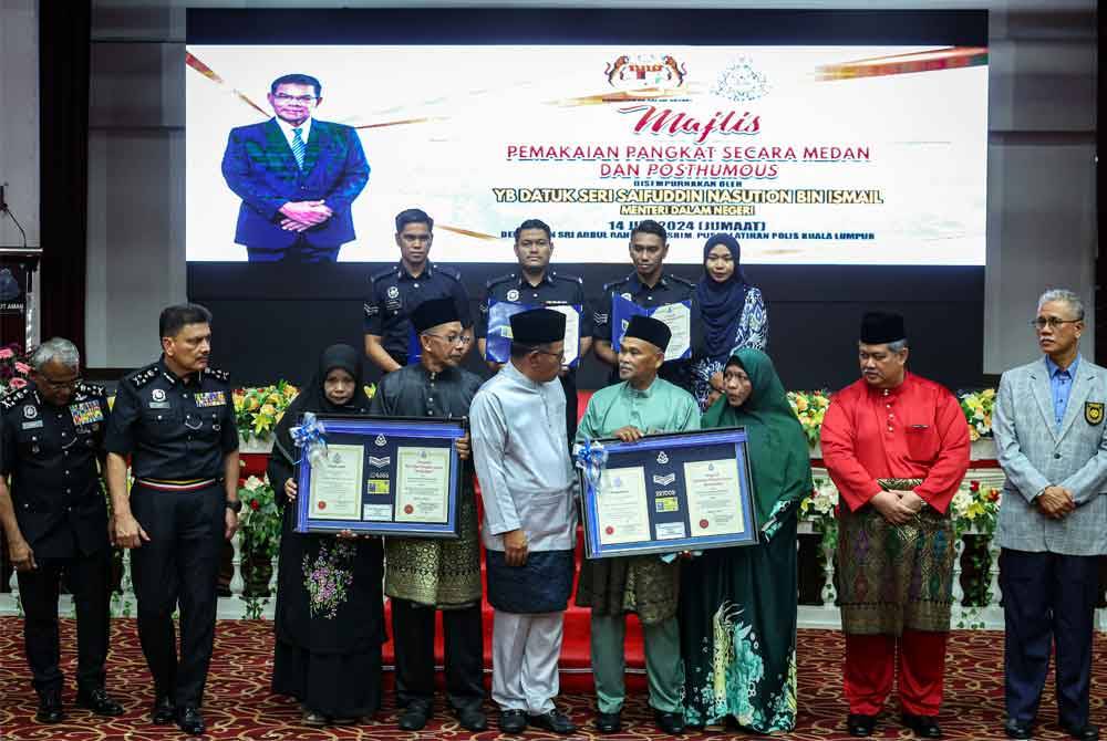 Saifuddin (lima dari kiri) beramah mesra dengan para penerima anugerah pada majlis pemakaian pangkat secara medan dan posthumous di Pusat Latihan Polis Kuala Lumpur. Foto Bernama