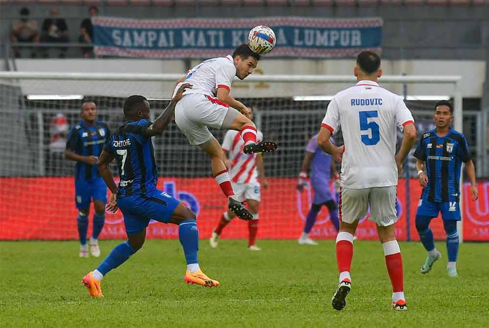 Pemain Kuala Lumpur City FC Ryan Edward (tengah) diasak oleh pemain Kuching City FC Tchetche Hermann pada perlawanan Piala FA di Stadium Kuala Lumpur Cheras malam ini. Foto Bernama