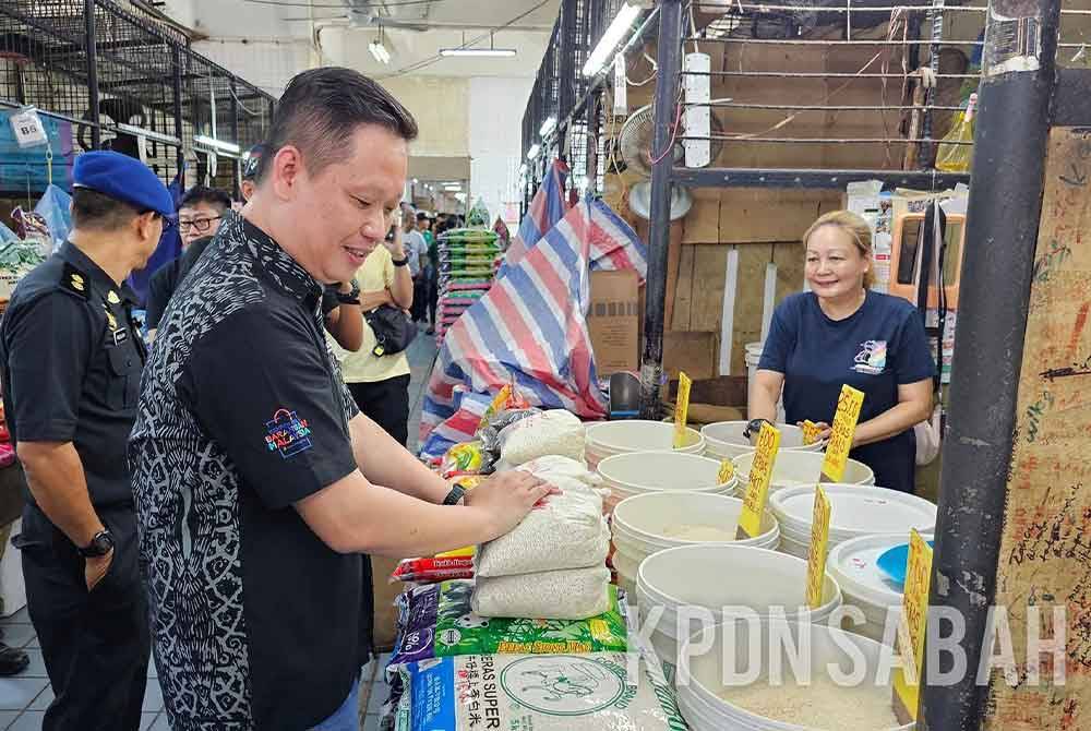 Georgie bersama anggota penguat kuasa KPDN Sabah menjalankan pemeriksaan harga dan bekalan bahan mentah di Pasar Besar Kota Kinabalu. Foto KPDN Sabah