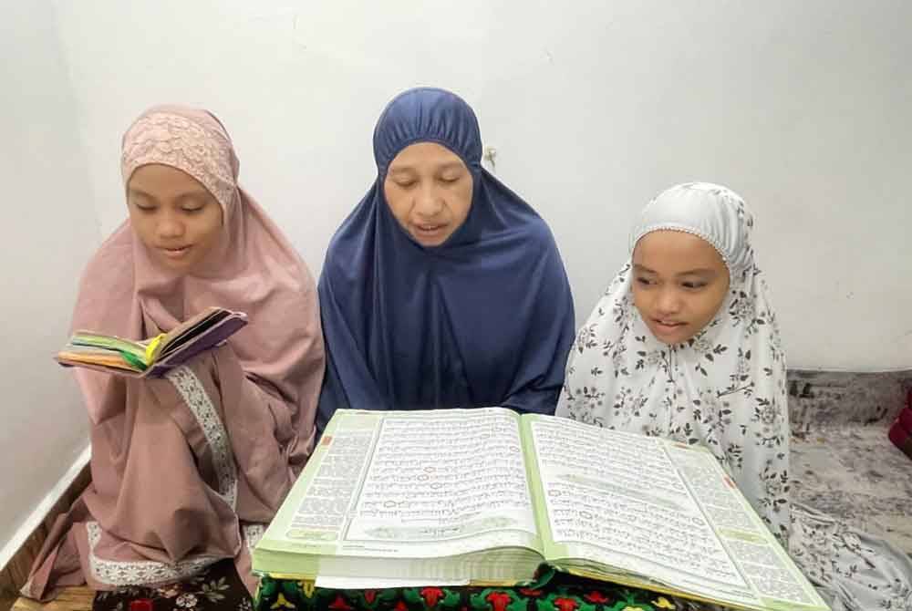 Aishah tengah bersama dua anak saudaranya, Qhalishah Ahmad Arshad,15, (kiri) dan Siti Nur Surfina Ahmad Arshad,11(kanan) mengikuti Arafah #QuranHour di sebuah homestay di Batu Kurau,Perak.