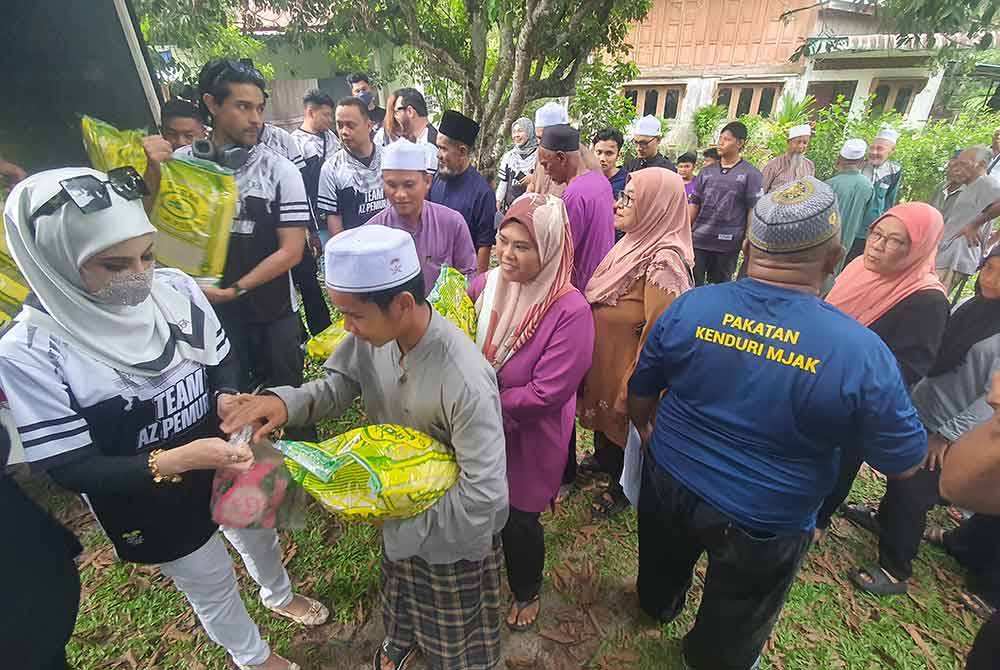 AZ pemurah (kiri) menyampaikan bantuan beras dan ayam kepada 500 penerima di kawasan Tun Sardon, Permatang Pauh bagi berkongsi rezeki dengan mereka.