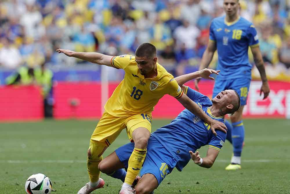 Pemain Romania, Razvan Marin (kiri) dan pemain Ukraine, Mykhailo Mudryk bersaing merebut bola pada aksi Euro 2024. FOTO: AFP