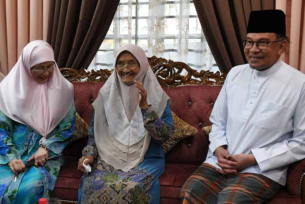 Anwar dan Dr Wan Azizah disambut oleh bekas guru agama Ustazah Salmah (tengah) di kediamannya di Cherok Tok Kun di sini hari ini. - Foto: Bernama