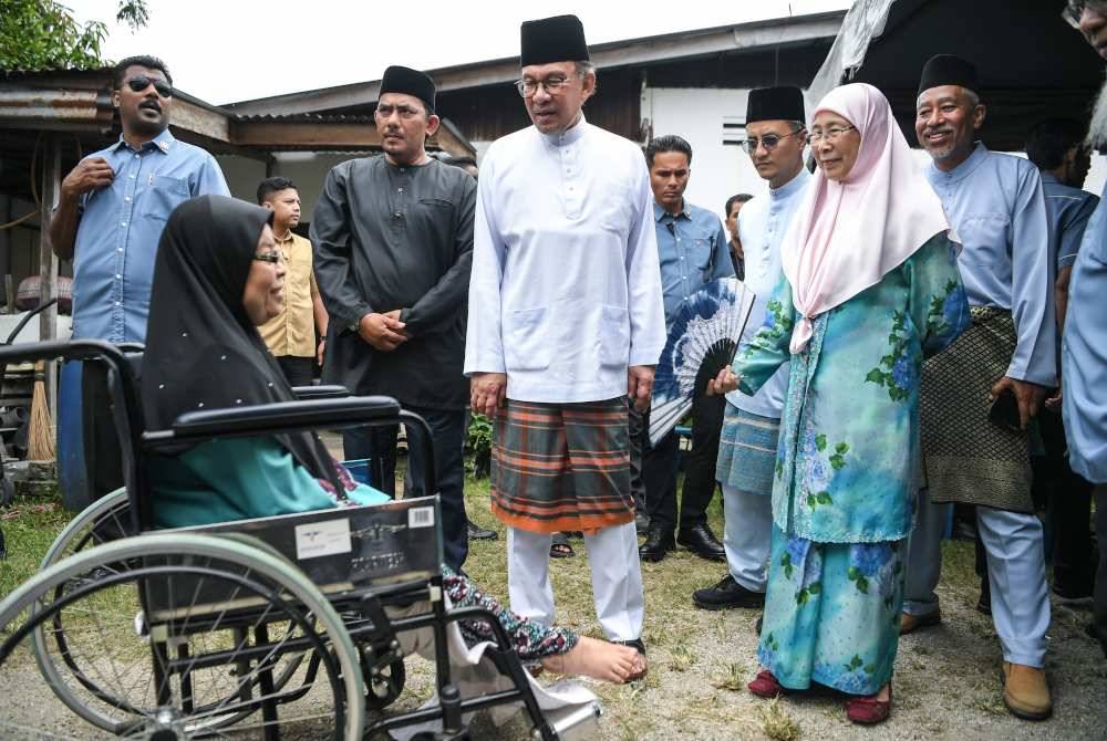 Anwar bersama Wan Azizah beramah mesra bersama penduduk setempat ketika hadir pada majlis kenduri sempena Hari Raya Aidiladha kenalan lamanya Hamzah Mat Isa di sini, pada Selasa. Foto Bernama