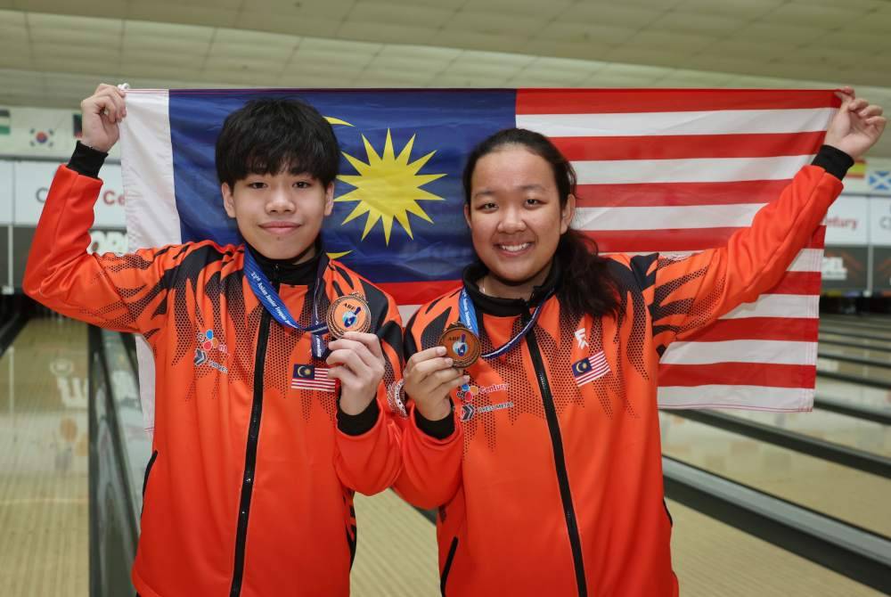 Ethan (kiri) dan Qurratu’ain Izdihar berjaya meraih tempat kedua selepas beraksi pada Kejohanan Tenpin Boling Remaja Asia ke-23 di Sunway Pyramid, pada Selasa. Foto Bernama