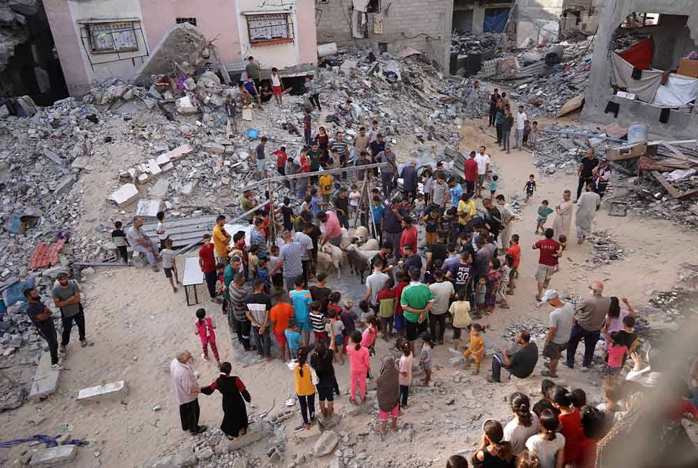 Sekumpulan penduduk Gaza mengerumuni beberapa ekor kambing untuk ibadah korban.